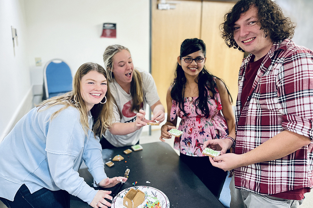 Chemistry students work together to make a gingerbread house.