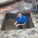 Nina Schreiner kneels in an excavation hole at Sesqui Park. Photo by Jack Allen.