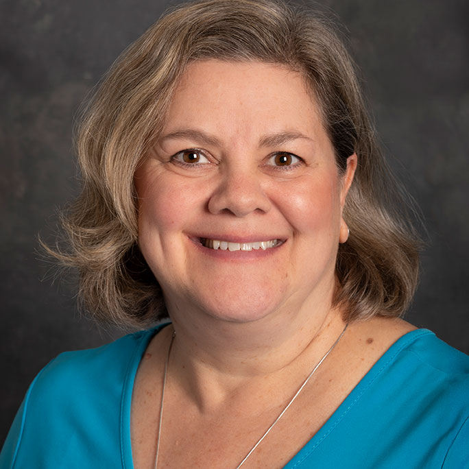 Photo of Tammi in a blue shirt smiling. 