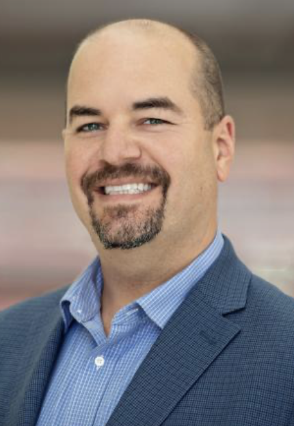Paul Jenkins, a White man with facial hair smiles at the camera