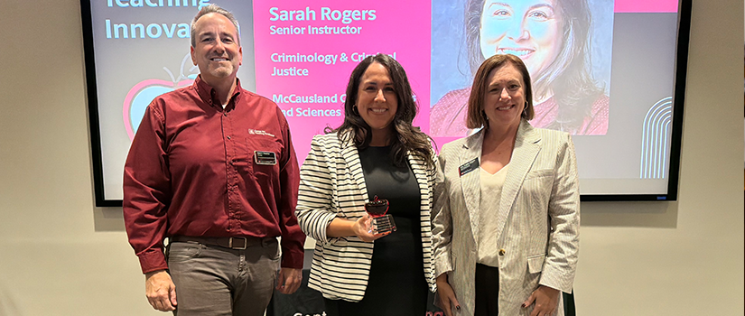 Sarah Rogers, center, holds her 2026 Garnet Apple Award while posing with two other people at the recognition event.