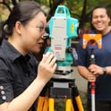 Graduate students working with surveying equipment