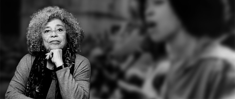 A black and white composite photograph shows Angela Davis from the waist up. She has shoulder-length curly hair and is wearing glasses, a long sleeve blouse, and a scarf. In the background, an out-of-focus photograph shows a young Angela Davis speaking to a crowd of people.