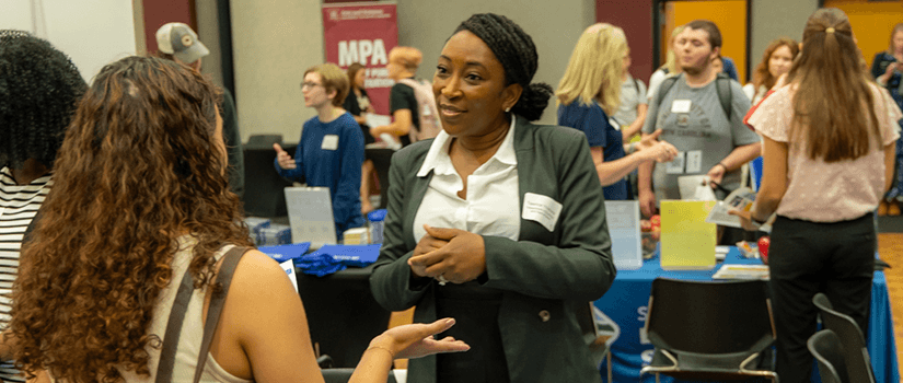 Students talking with potential employer. 
