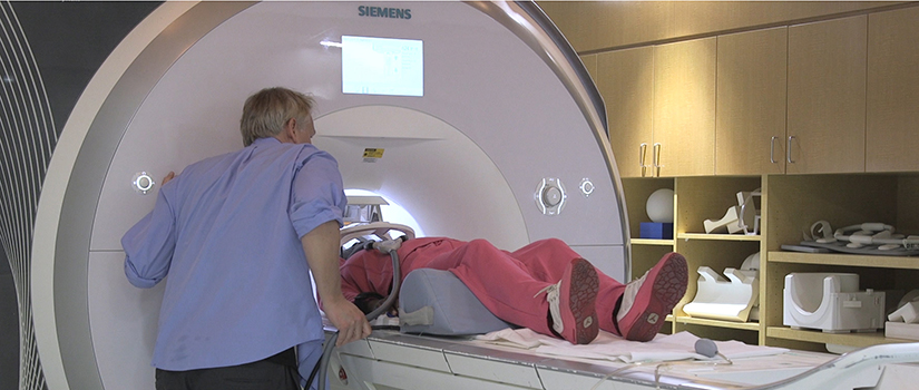 Roger Newman-Norlund assists someone in the MRI.