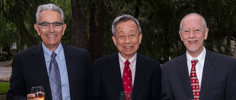 photo of three men in suits at an event 