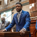 Pendarvis stands at a podium in the SC State House wearing a blue suit.