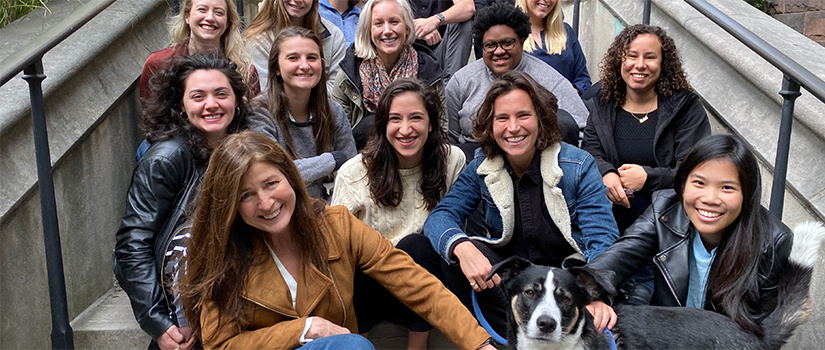 BJ Casey and a group of students from the 2019-2020 cohort of the FAB lab at Yale University. Accessibility text: BJ Casey sits with a group of students on the steps of a Yale University building. They are all smiling for the camera as Casey reaches out and holds onto a dog, the lab mascot.