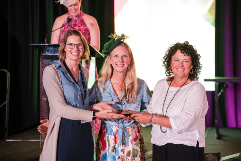 Two USC researchers receive the 2026 National Fragile X Foundation Research Award from a presenter during the foundation’s international conference.