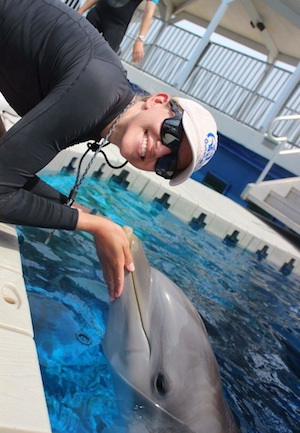 Kate McAlister (’13 marine science) helps a dolphin at the Gulfarium.