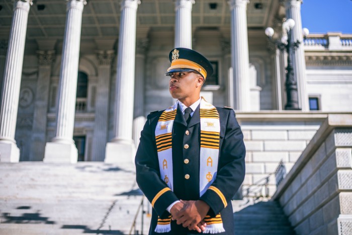 Dajuan McDonald in blue military uniform and an Alpha Phi Alpha stole draped over his shoulders.