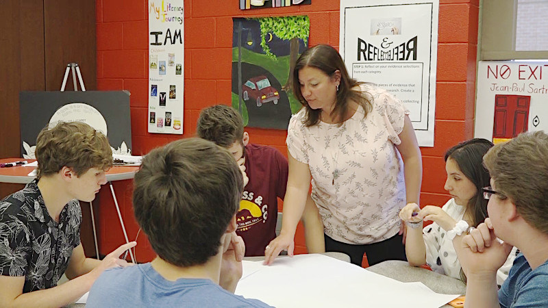 Sarah Gams teaching students seated around a table