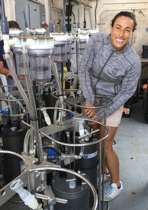 Claudia Benitez-Nelson works with research equipment on a boat