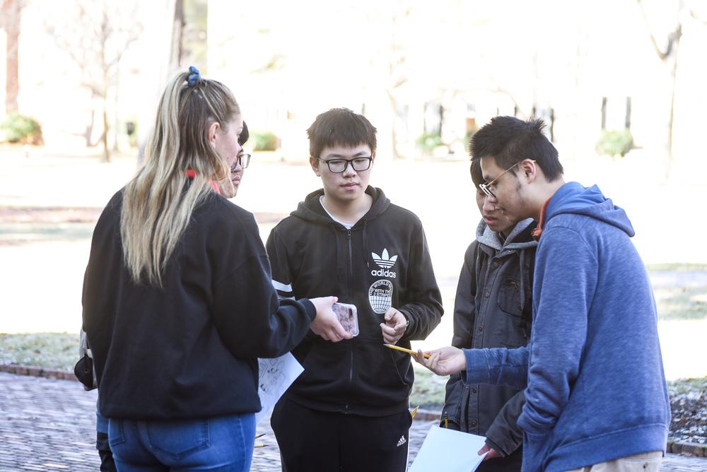 Students discussing a math problem in the park