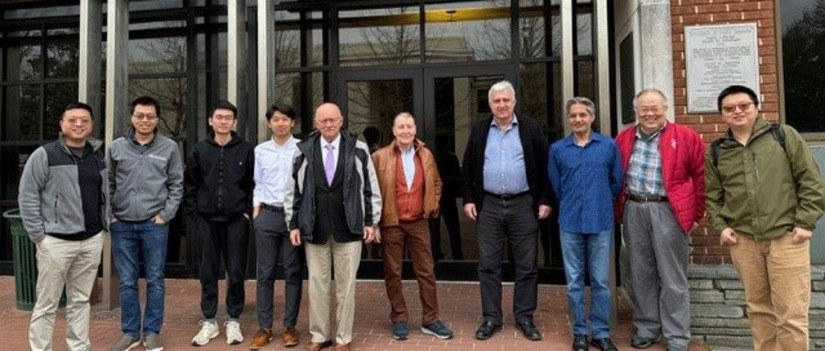 Banner Image of ten people standing in front of a building