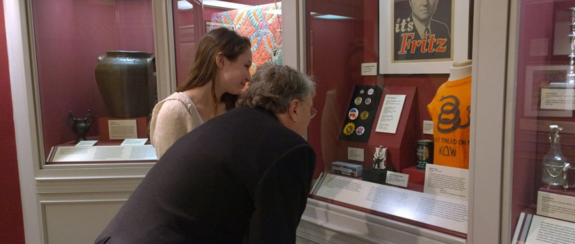 Group examining artifacts in a glass case.