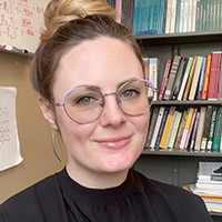 photo of a woman with black sweater on and glasses