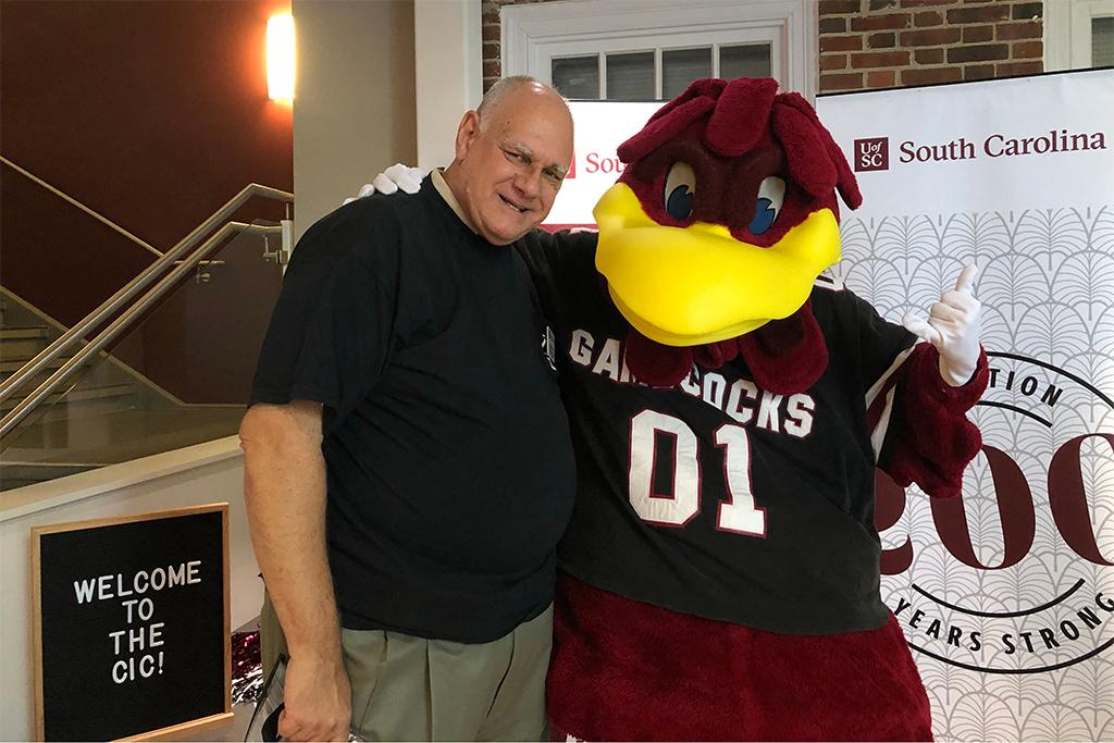 Doug Fisher with Cocky at a college event in the journalism building.