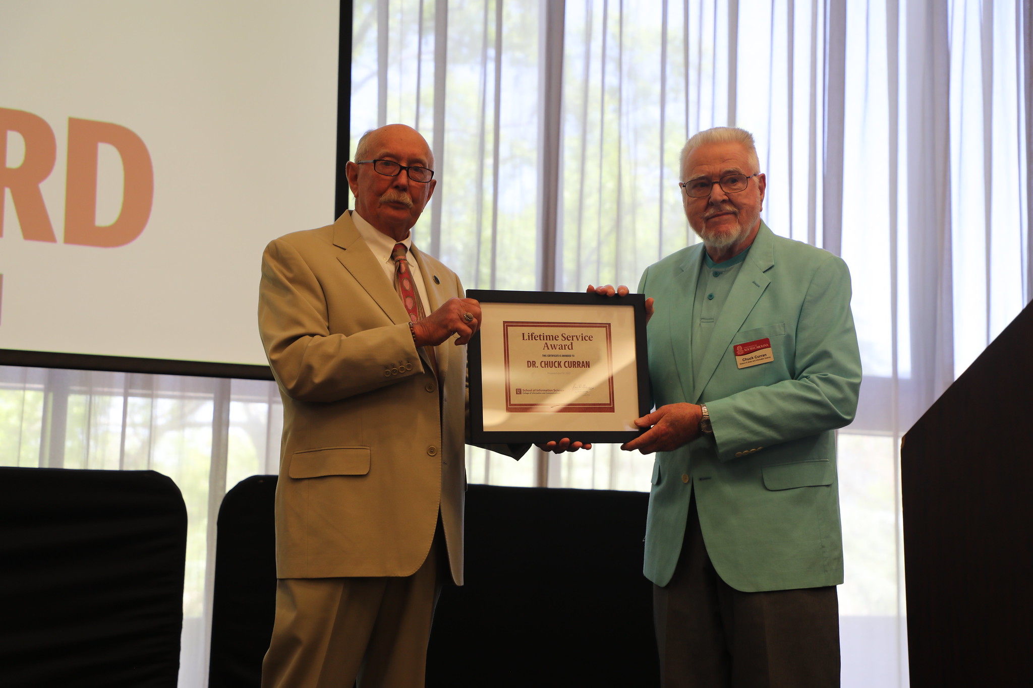 Dr. Dan Barron presents Dr. Charles Curran with a Lifetime Service Award.
