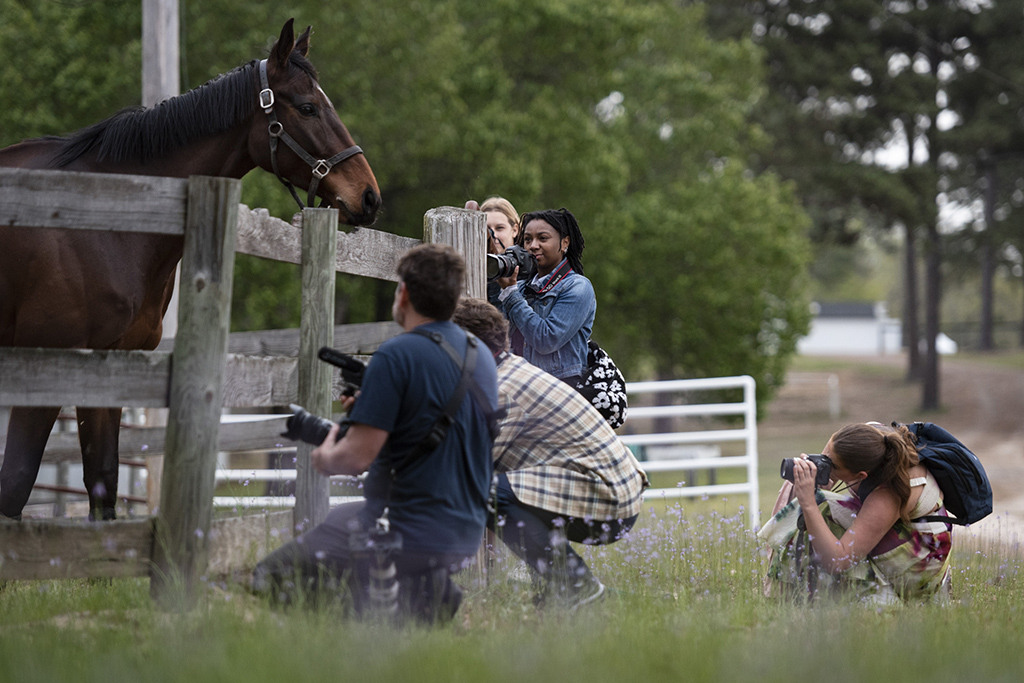 Photography coach John Wollwerth, foreground guides student photographers as they participate in the Talmadge Moore LeGrand photojournalism workshop at the 88th running of the Carolina Cup, a steeplechase racing event in Camden, S.C. 