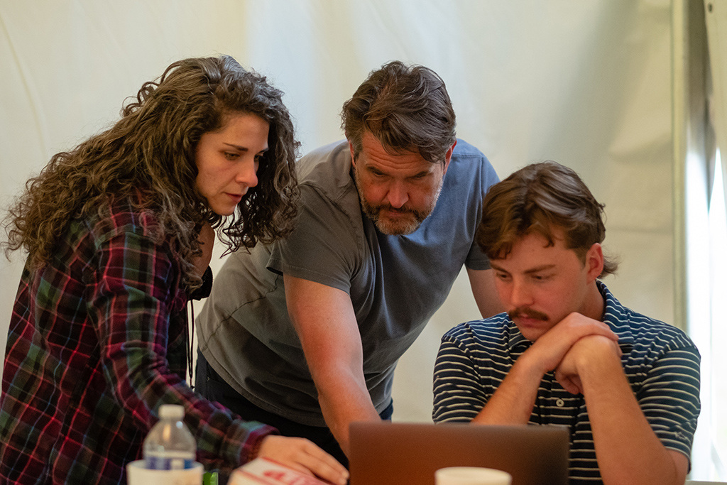 Photographers Allison Isley, left, and John Wollwerth give advice to student Aidan Peck as he edits photographs from the 88th Running of the Carolina Cup in Camden. 