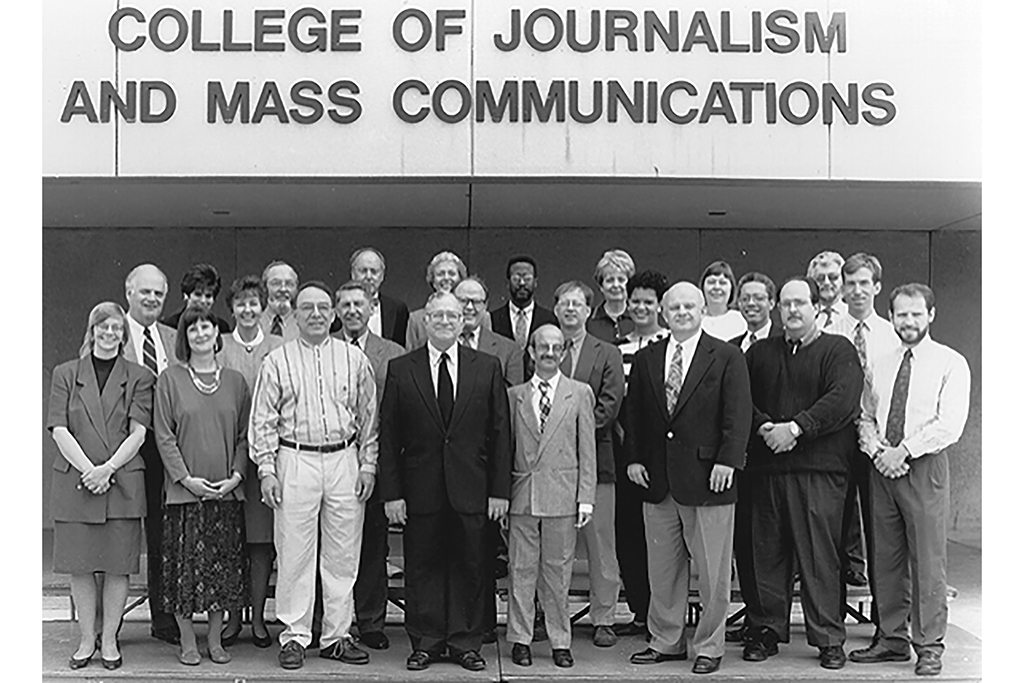 Faculty in 1995 - Gathered in front of the College of Journalism and Mass Communications are (front row, l to r) Bonnie Drewniany, Lynn Zock, Jerry Jewler, John Lopiccolo, Alan Fried, Jon Wardrip, David Thompson, Van Kornegay; (second row, l to r) Henry Price, Pat McNeely, Ron Farrar, Rick Stephens, Bruce Konkle, Lauren Tucker, Ernie Wiggins, Keith Kinney; (third row, l to r) Sonya Duhe, Jay Latham, Erik Collins, Dean Judy VanSlyke Turk, Kenneth Campbell, Mary Caldwell, Beth Dickey and Lou Brierley.