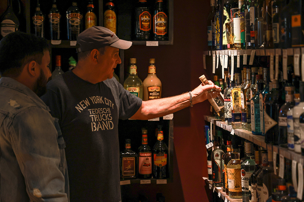 Photo by Xavier Martin: Store manager Tom Wasserman grabs a bottle of tequila while helping a customer on Oct. 7, 2023, in Jeffersonville, NY. 