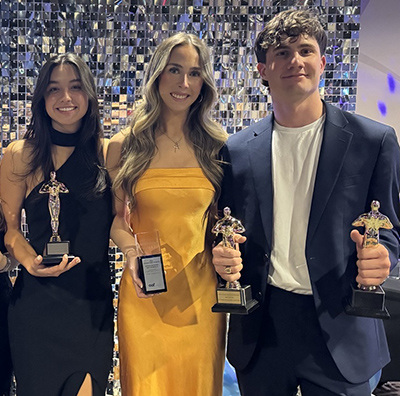 three students holding Gold awards