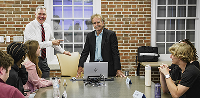 class sitting around a table listening to Sammy Fretwell