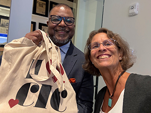 Leroy Chapman holding an "I love CIC" bag and Laura Smith.