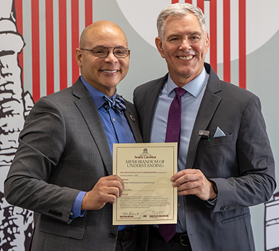 Craig Wilson and Tom Reichert holding the Memorandum of Understanding they just signed