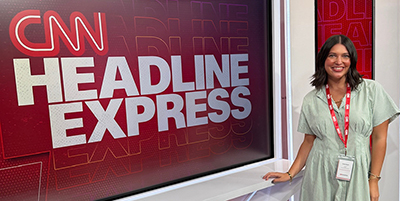 Emma Wyatt standing in front of a "CNN Headline Express" sign
