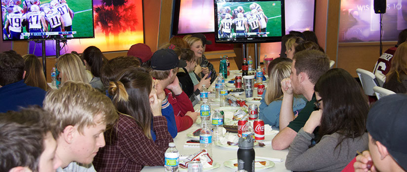 The class enjoys the typical Super Bowl food while watching the game and rating the ads.