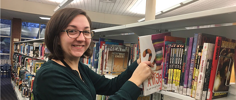 Ashley Griffith shelving books in the library.