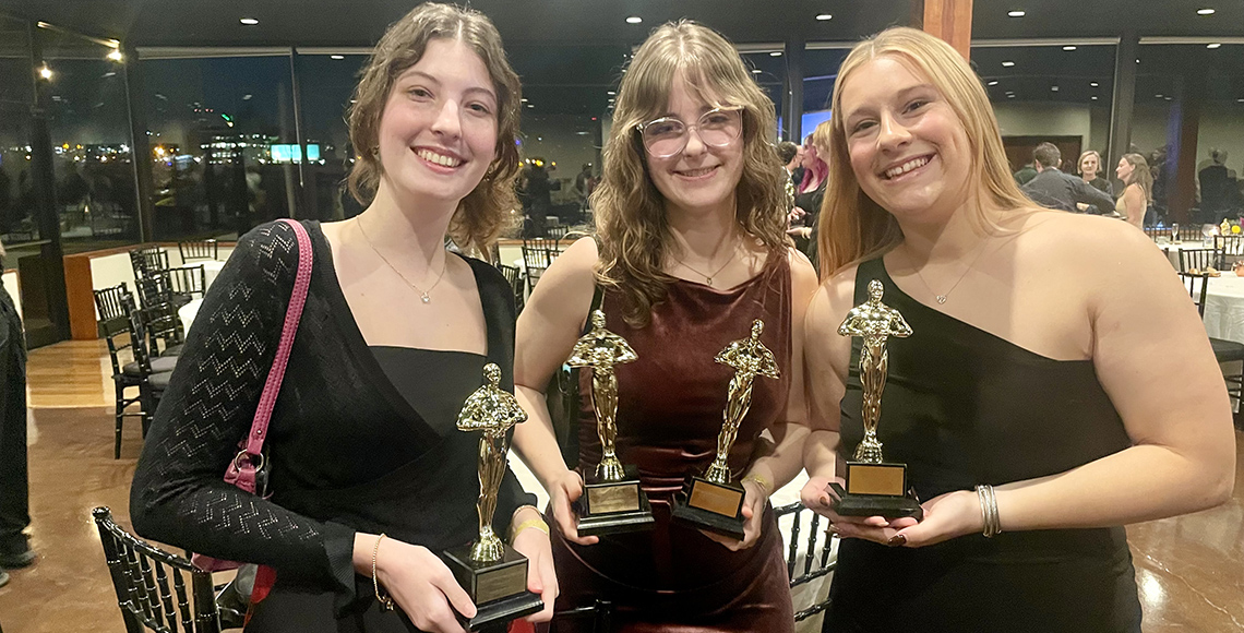 girls holding trophies