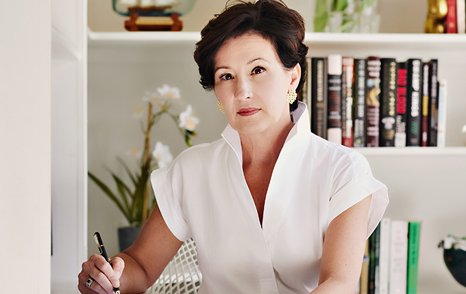 Valerie bauerlein sitting in front of a bookshelf