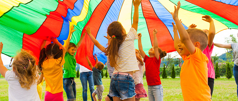 children playing undernath a parachute