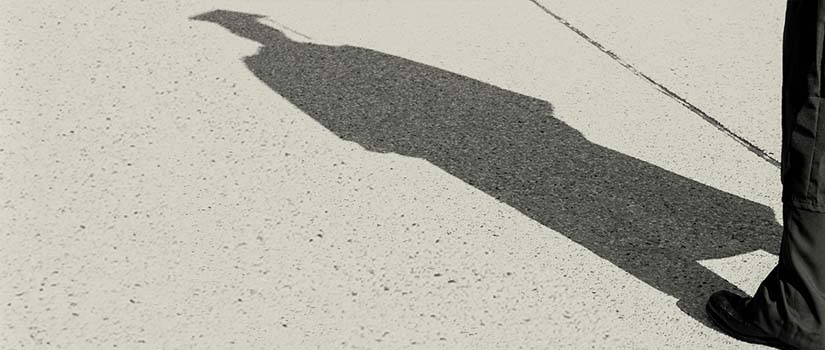 the shadow of a person in a graduation cap and gown