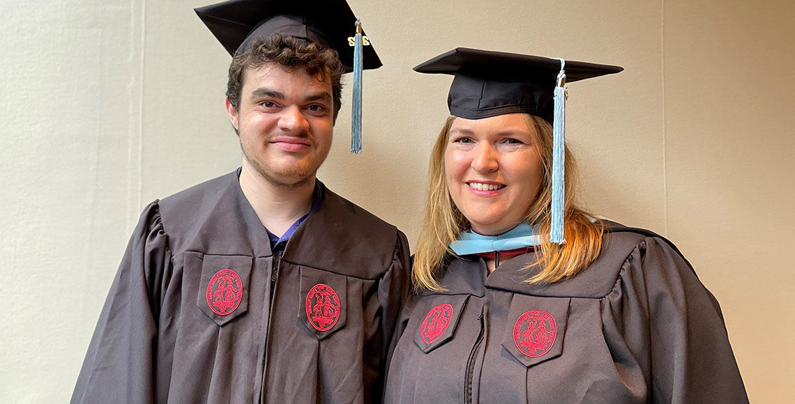 two people wearing graduation regalia
