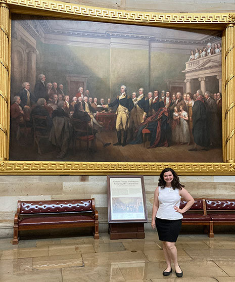 Gracie Vess in a museum standing by a painting.