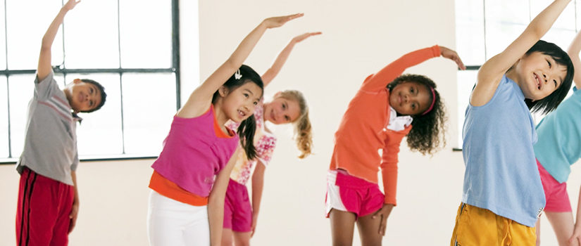 several children of mixed genders and races doing group stretching exercises