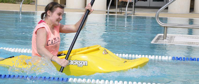 Female CarolinaLIFE student in a kayak in a swimming pool.
