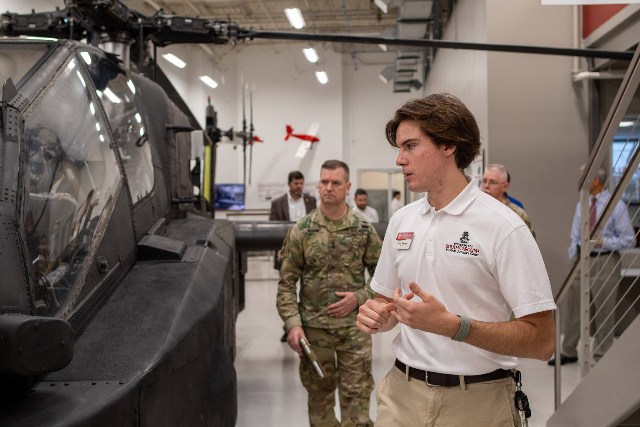 A student leads AMCOM Commander Maj. Gen. Todd Royar around the Apache Airframe in the McNair Center.