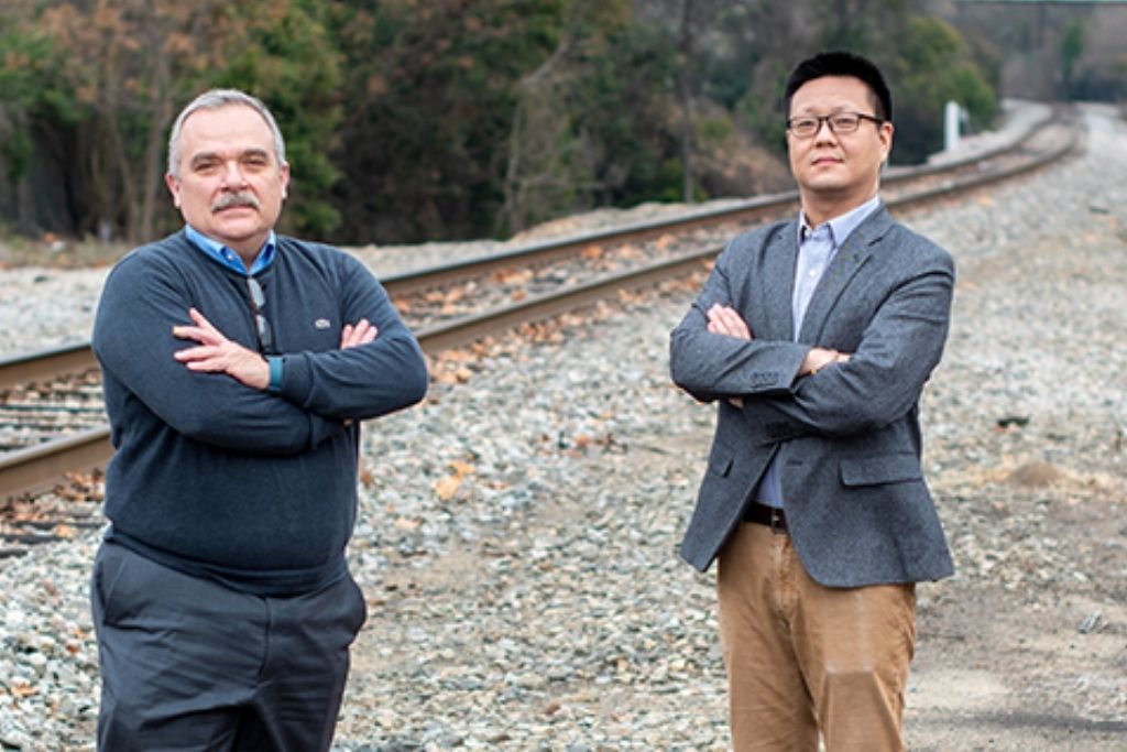 Qian and Rizos standing by railroad.