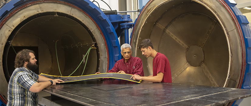 three people look at a composite material