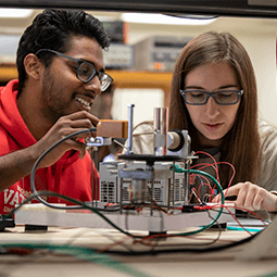 a male and female student work together in an electrical engineerin lab
