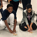 two students test experiment in the hallway