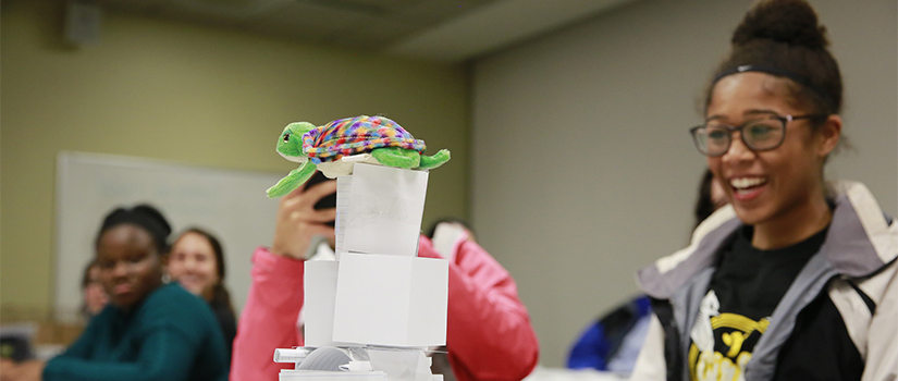 date night participant smiles at paper tower with stuffed turtle on top