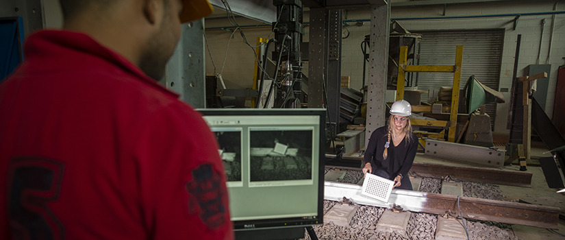 two graduate students work in the railway lab