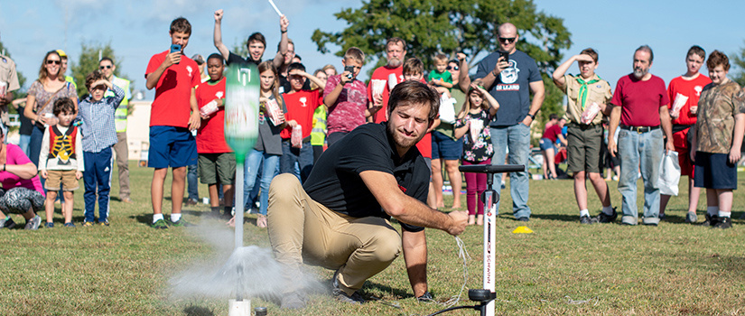 Students cheer as bottle rockets shoot off
